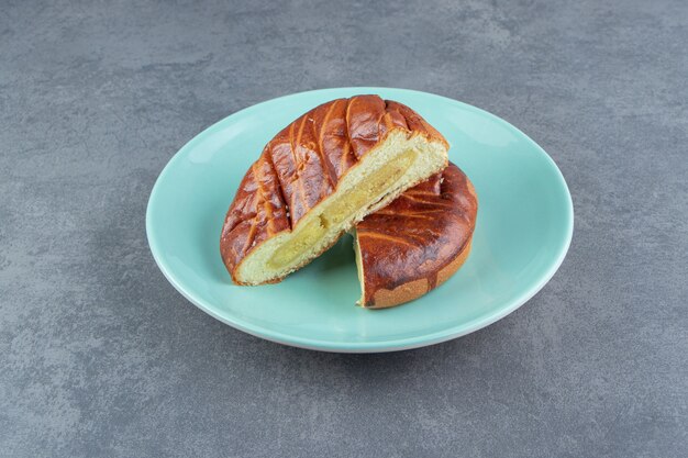 Half-cut homemade pastry on blue plate. 