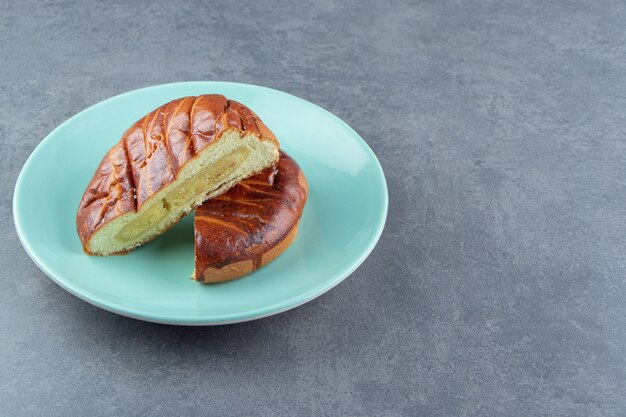 Half-cut homemade pastry on blue plate.