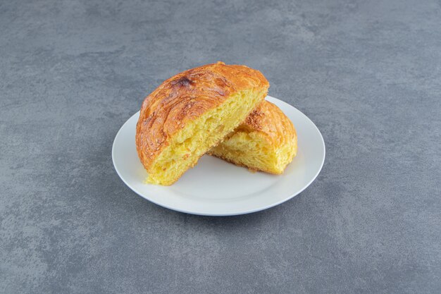 Half-cut homemade pastry on white plate. 