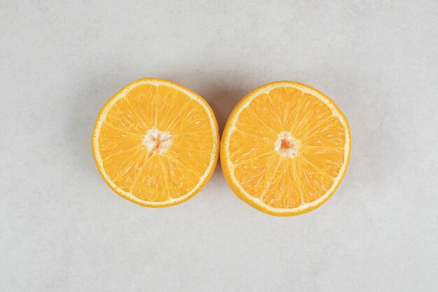 Half cut juicy orange on gray surface.