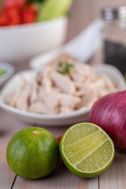 Free photo half cut lemons and red onions placed on a wooden table.