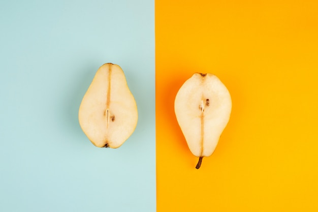 Half cut pears mellow juicy fruits on a colored desk