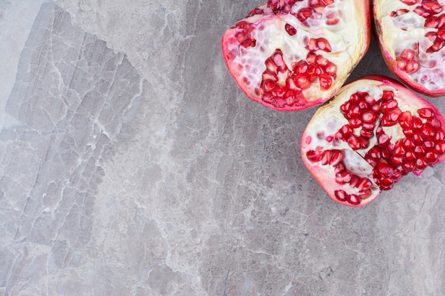 Half cut red pomegranates on stone background. 