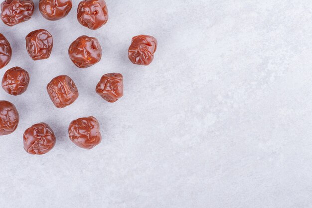 Half dried brown sour cherries isolated on concrete surface