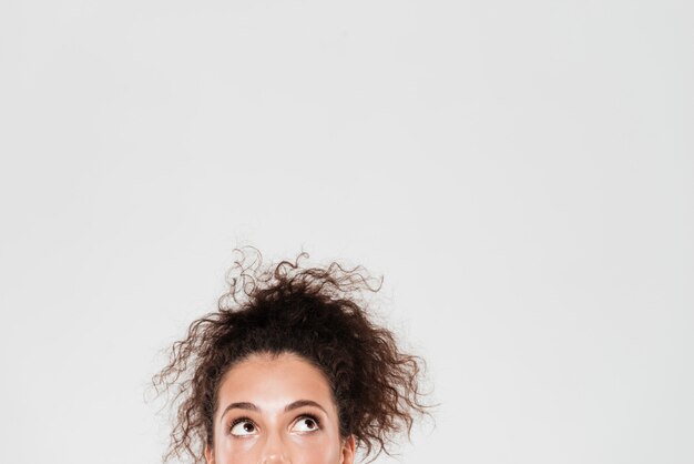 Half face of pretty curly woman looking up