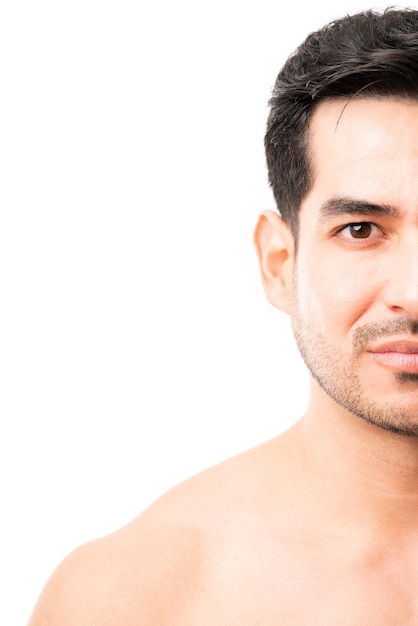 Half face of a young latin male model with beard in studio