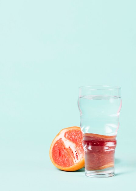 Half of grapefruit with glass of water