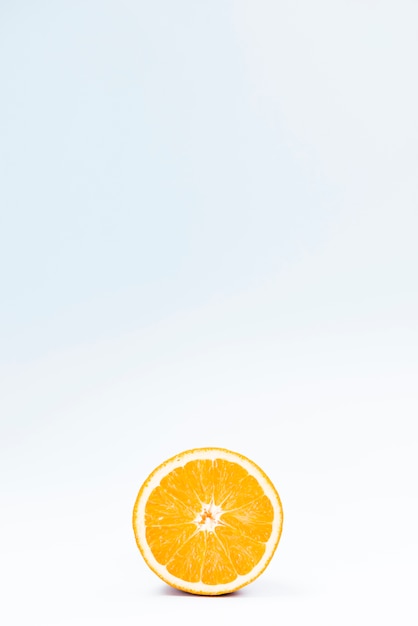 Free photo half of juicy citrus fruit on white blue background