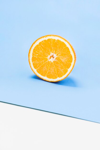 白と青の背景にジューシーオレンジの半分