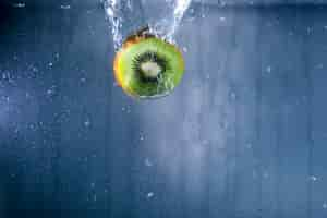 Free photo half kiwi surrounded by water