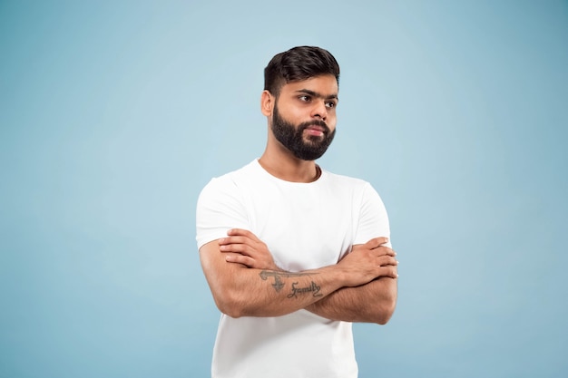 Half-length close up portrait of young man on blue.