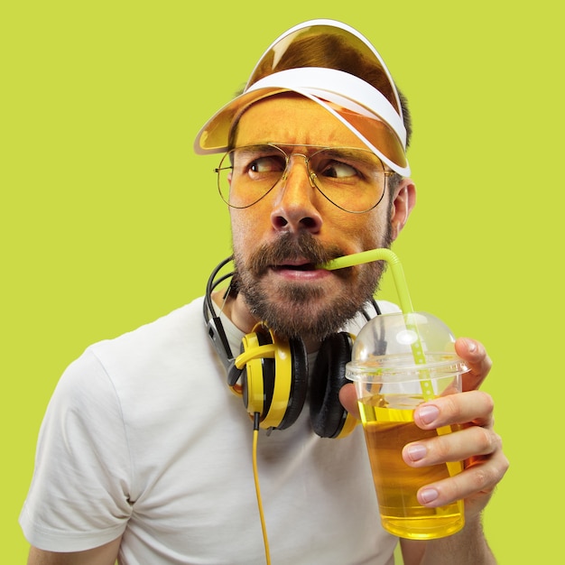 Free photo half-length close up portrait of young man in shirt. male model with headphones and drink. the human emotions, facial expression, summer, weekend concept. asking and looking.