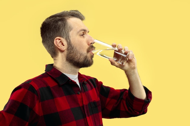 Free photo half-length close up portrait of young man in shirt on yellow space