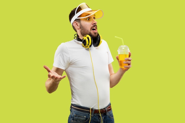 Half-length close up portrait of young man in shirt on yellow space