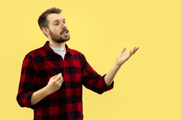 Half-length close up portrait of young man in shirt on yellow