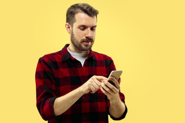 Free photo half-length close up portrait of young man in shirt on yellow