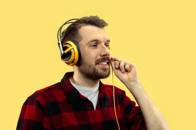 Free photo half-length close up portrait of young man on yellow.