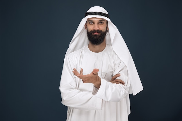 Free photo half-length portrait of arabian saudi businessman on dark blue studio wall