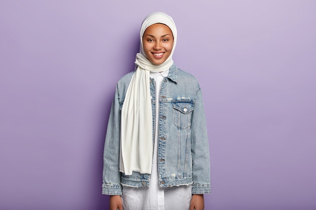 기쁜 아라비아 여성의 절반 길이 샷은 흰색 히잡, 데님 재킷을 착용