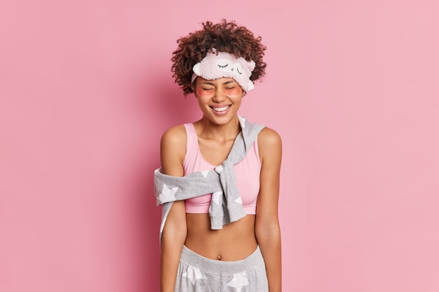 Half length shot of smiling Afro American woman with dark skin enjoys beauty procedures