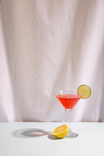 Free photo half lime with cocktail drink garnish with cocktail on desk against isolated on white background