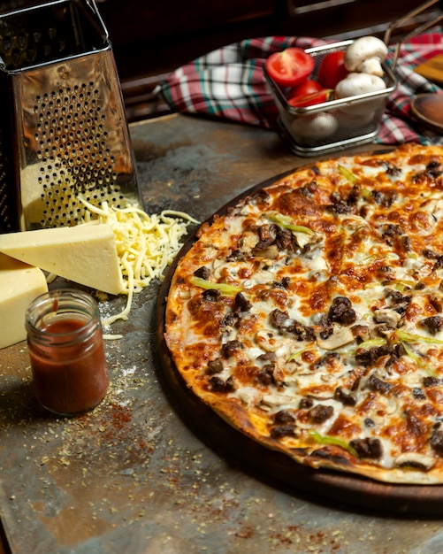Foto gratuita la metà della pizza a base di carne con peperoni e formaggio