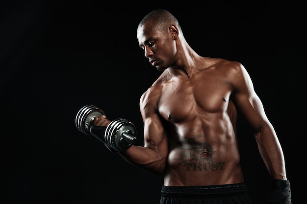 Free photo a half naked young afroamerican sportsman lifting dumbbells