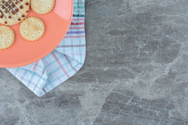 Half of orange plate in angle. Homemade cookies on plate.