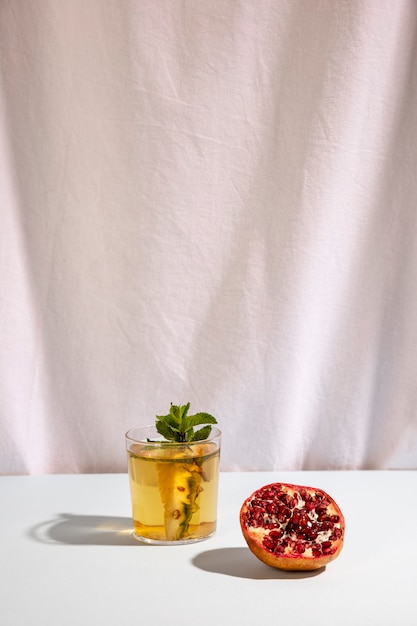 Half pomegranate with delicious drink on table