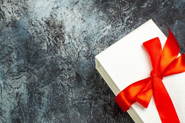 Half shot of beautifully packaged gift boxes tied with red ribbon on the right side on dark