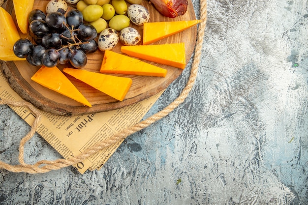 Half shot of best snack with various fruits and foods on a wooden brown tray rope on an old newspaper