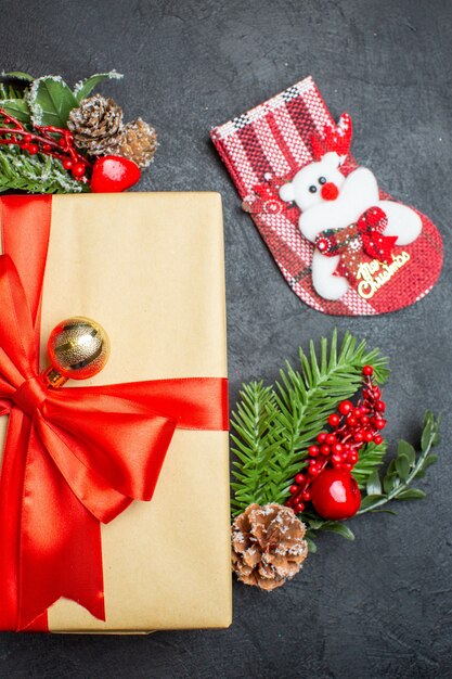 나비 모양의 리본과 전나무 가지 장식 액세서리 크리스마스 양말과 아름다운 선물로 크리스마스 분위기의 절반 샷 어두운 배경 세로보기