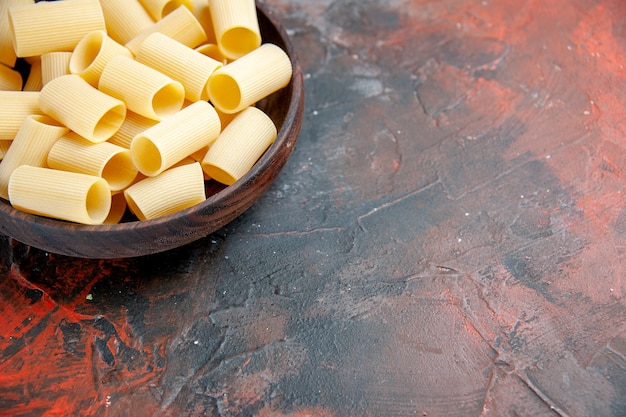 Half shot close up view of uncooked pastas inside the brown pot on black table footage