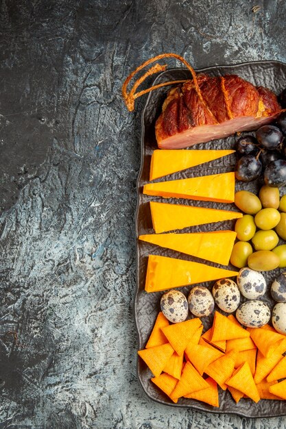 Half shot of delicious best snack for wine on brown tray on the right side on ice background