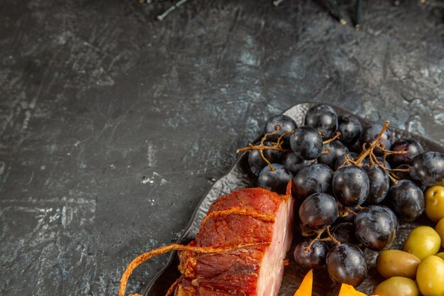 Half shot of delicious best snack for wine served on brown tray on gray background