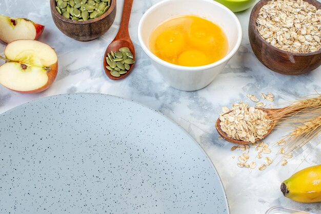 Half shot of empty gray plate and fresh healthy food set on ice background