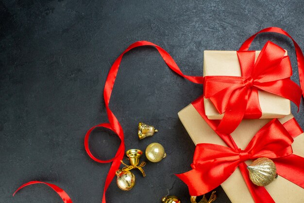 Half shot of gift box with red ribbon and decoration accessories on dark background