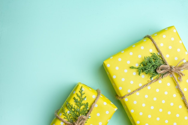 무료 사진 파스텔 녹색 배경에 다양한 크기의 노란색 선물 상자가 있는 크리스마스 배경의 절반