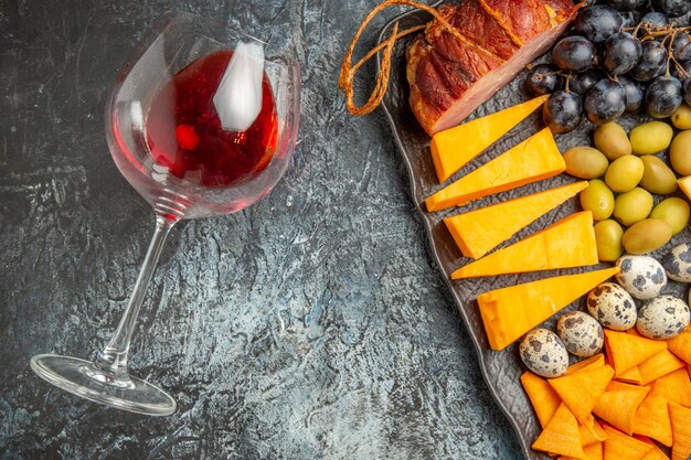 갈색 쟁반에 있는 맛있는 최고의 간식 반샷과 얼음 배경에 떨어진 와인 잔