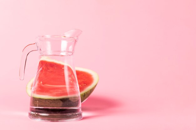 Half sliced watermelon with jug of water