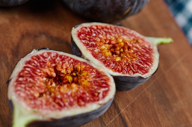 Half slices of ripe fig on wooden board.