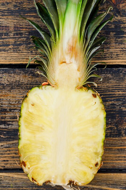 Half of tasty pineapple on old wood grunge. close-up.