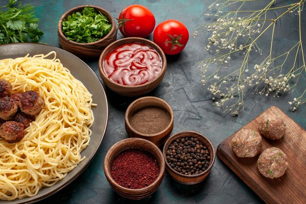 Half-top view cooked italian pasta with different seasonings on the dark-blue surface