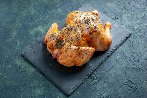 Half-top view cooked spiced chicken on dark surface