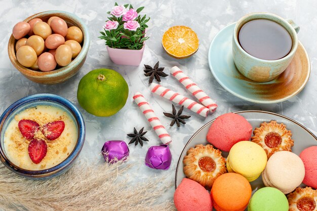 밝은 흰색 표면 사탕 과일 달콤한 차에 디저트 쿠키 케이크와 confitures와 차의 하프 탑보기 컵
