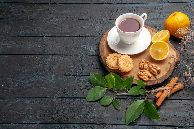 Half-top view cup of tea with fruits and cookies