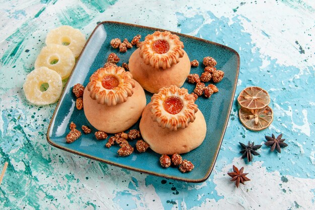 Half-top view delicious cookies with dried pineapple rings on light blue surface cookie biscuit sweet sugar color