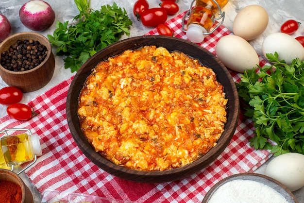 Half-top view delicious omelette with fried tomatoes around greens and vegetables on white background morning breakfast bread milk lunch