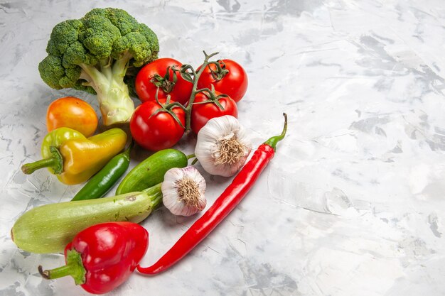 Свежая брокколи с овощами на белом столе, салат, спелая здоровая диета