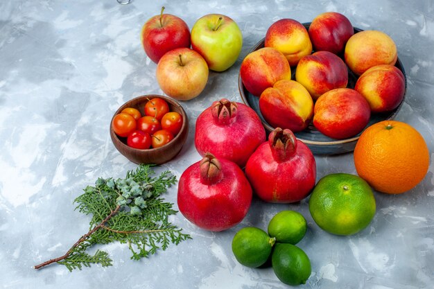 Half-top view fresh peaches delicious summer fruits with tangerines and apples on light white desk fresh fruits mellow vitamine ripe tree